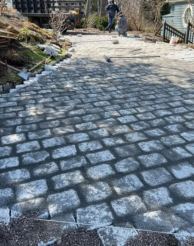 Cobblestone-style paver walkway leading to a Maine home