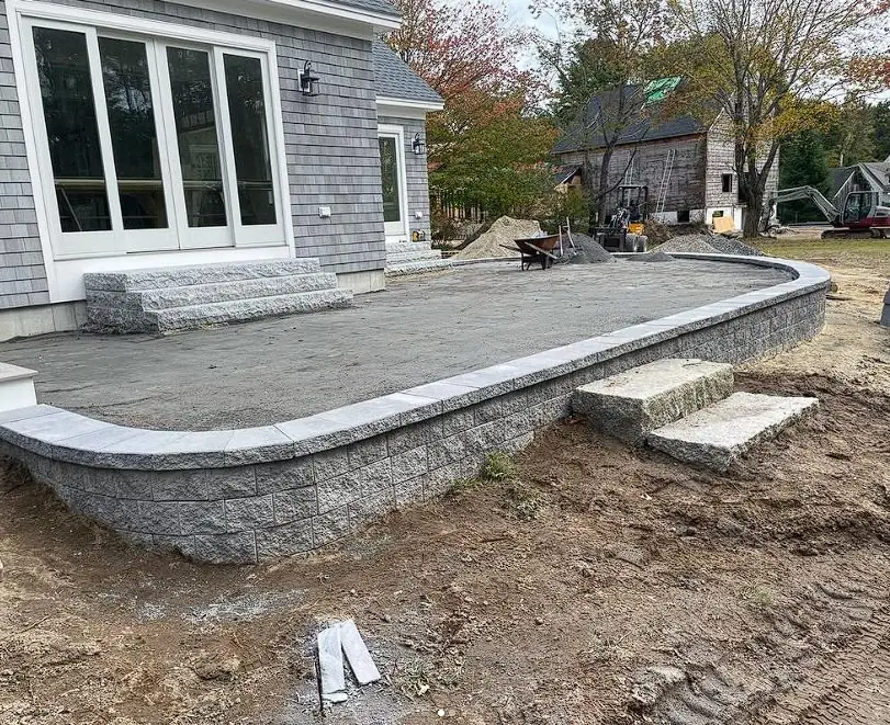 Curved paver patio with stone steps nearing completion