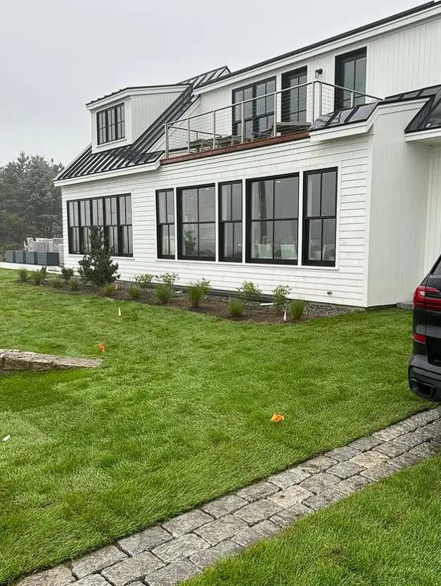 Manicured estate lawn with a paver walkway maintained by Billy Goat Landscaping