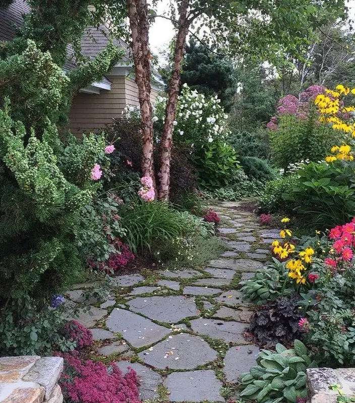 Flagstone garden path bordered by perennial flowers in Southern Maine