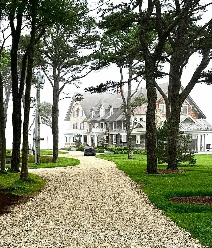 Tree-lined gravel driveway approach to a Southern Maine estate