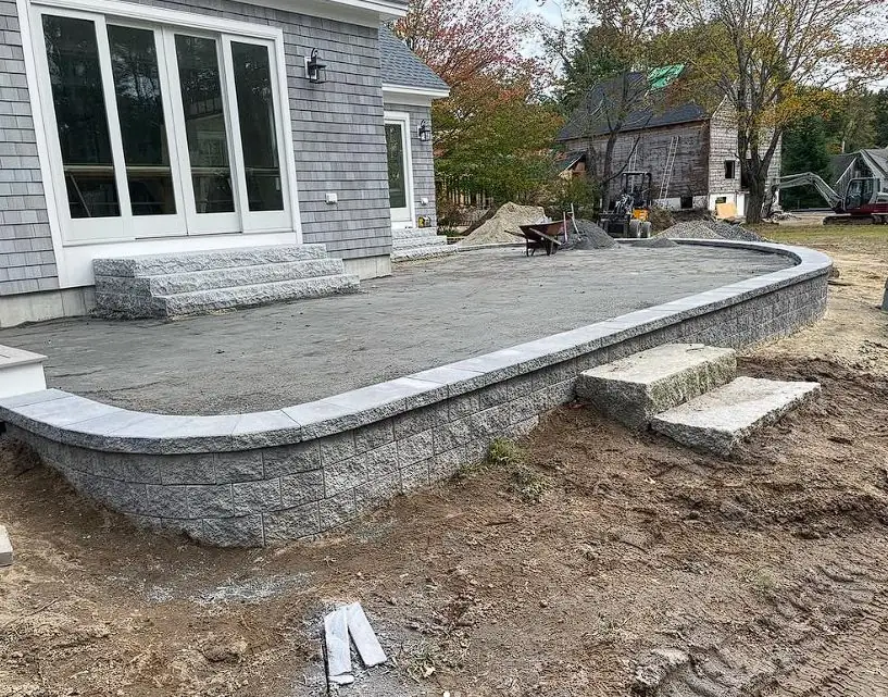 Stone patio and retaining wall under construction by Billy Goat Landscaping
