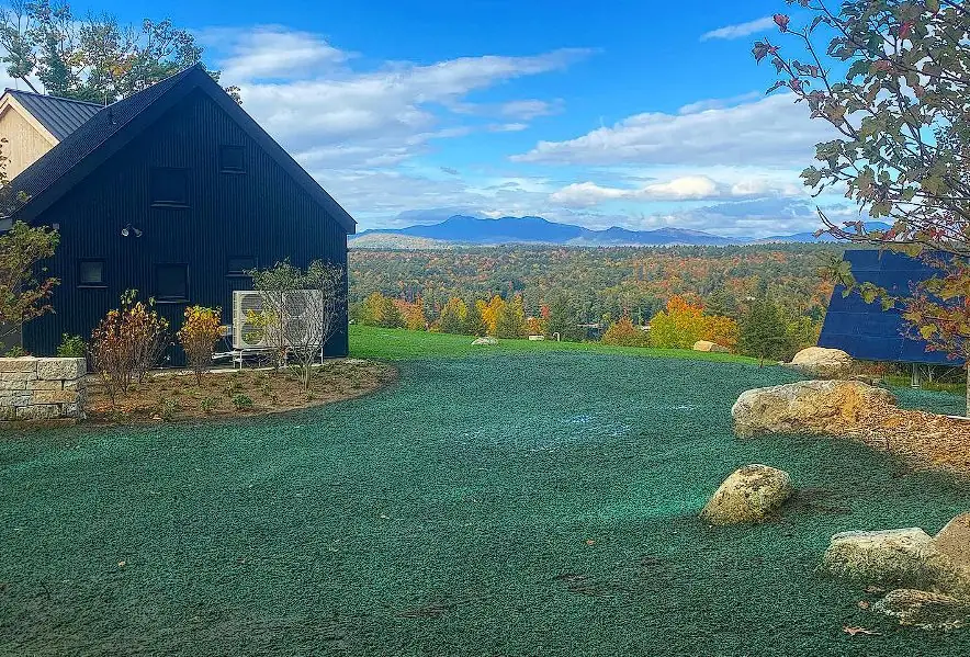 Hydroseeded lawn at a Maine farmhouse with fall foliage in the background