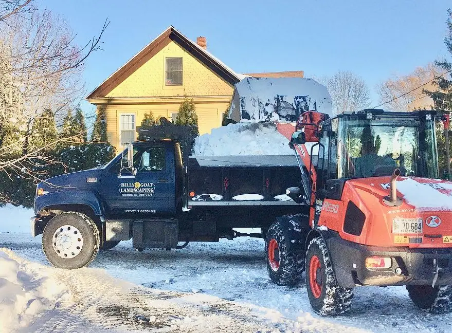 Hydroseeding slurry tank and tractor at a Maine farmhouse job site