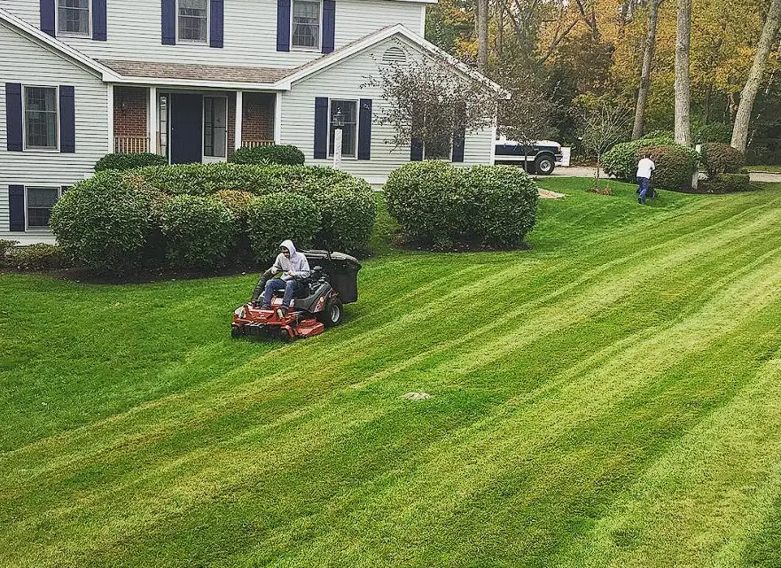 Billy Goat Landscaping crew mowing a striped lawn in Kennebunk, Maine