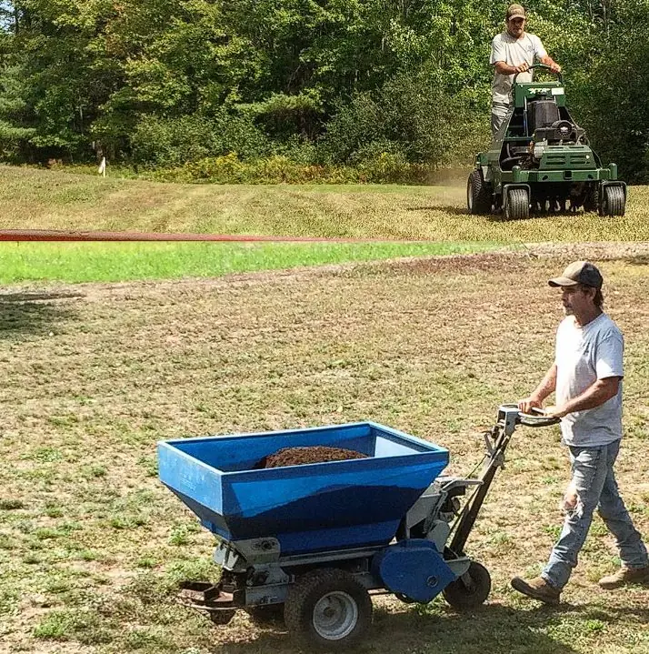 Billy Goat Landscaping technician topdressing and overseeding a Maine lawn