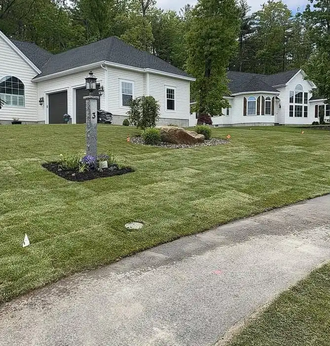 Manicured lawn and paved driveway maintained by Billy Goat Landscaping in Kennebunk, Maine