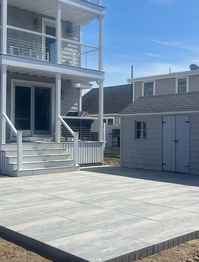 Raised deck and paver patio at a multi-level Southern Maine home