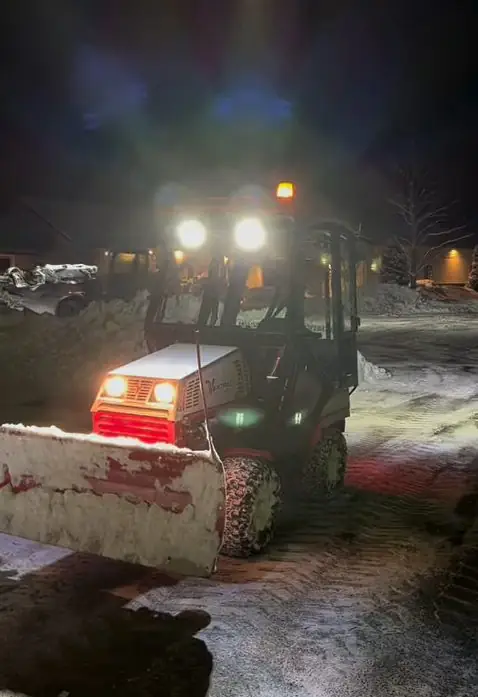 Billy Goat Landscaping plow truck clearing snow at night