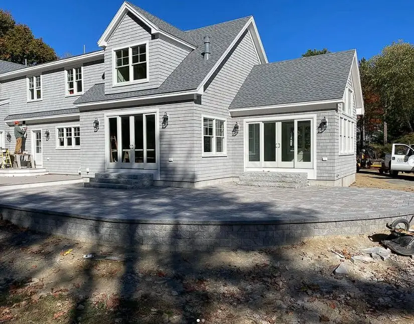 Paver driveway and patio at a gray-shingled Southern Maine home