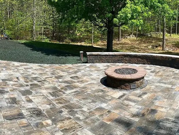 Circular paver patio with a built-in fire pit installed in Southern Maine