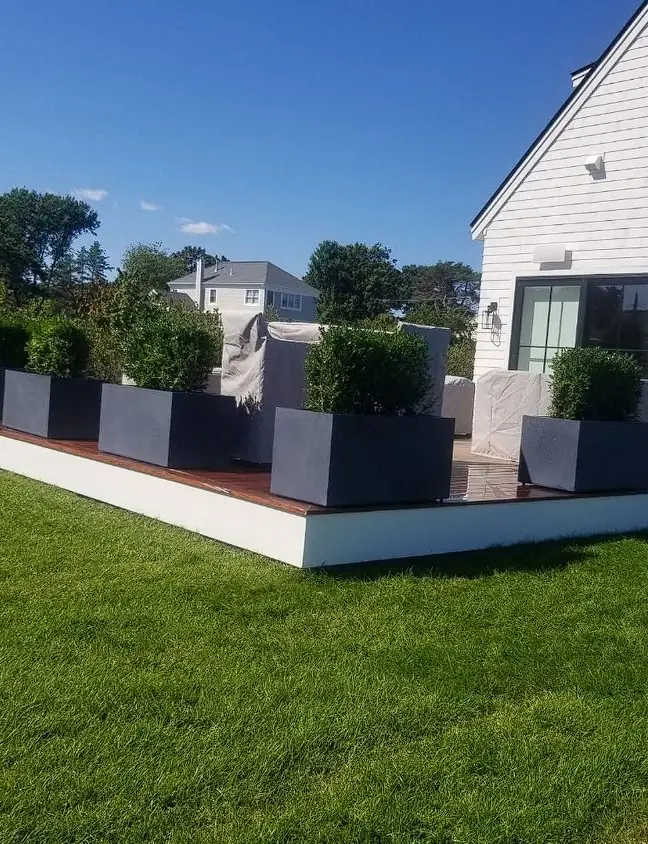 Raised paver patio with planter boxes at a modern Maine home
