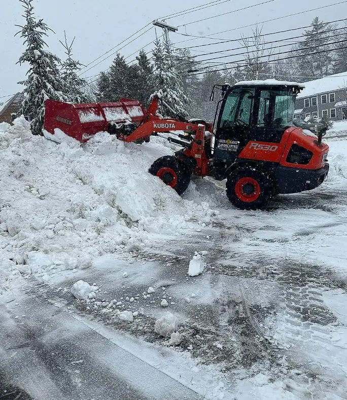 Loaders clearing snow from a commercial lot in Southern Maine