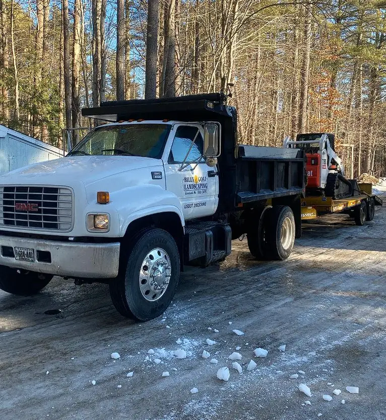 Billy Goat Landscaping dump truck with plow clearing a Maine road